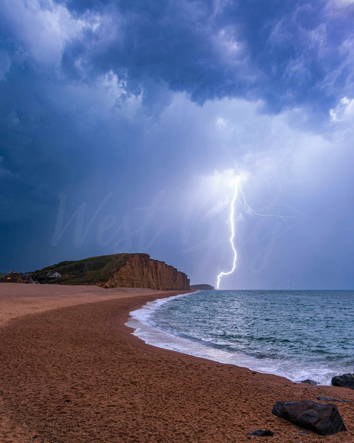 Lightning strike over East Cliff and the sea at West Bay, Dorset